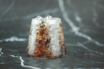 A glass of soft drink with ice cubes