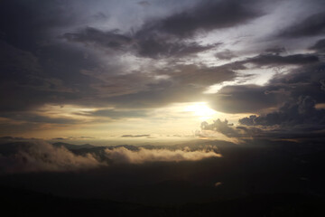 Destination twilight and paradise of golden sunrise and sunset shining to the mist and fog in the jungle on the valley mountain. Aerial view of Rainy season in the tropical rainforest in Thailand.