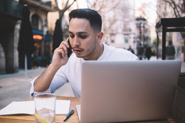 Concentrated ethnic man having conversation on smartphone