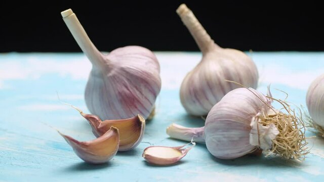 Close up fresh raw garlic on the table on black background. Dolly shot