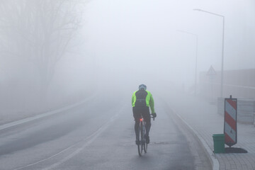 Mann fährt bei Nebel Fahrrad