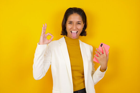 Portrait of a pretty happy Caucasian girl taking a selfie isolated over bright background