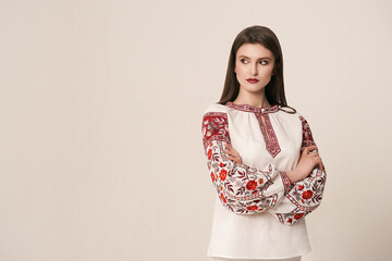 Young beautiful brunette girl wearing gorgeous ethnic style embroidered shirt, modern derivative...