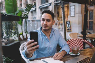 Young pensive male freelancer trying to catch Wi Fi