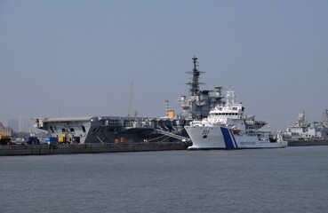 Indian Viraat aircraft carrier and Coast Guard ship anchored at a port in Mumbai, India
