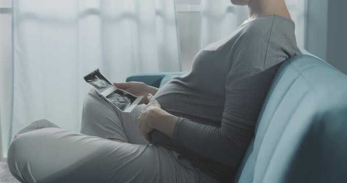 Pregnant woman watching ultrasound images of her baby