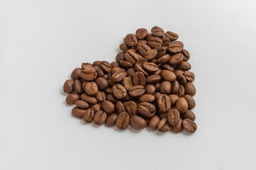 Coffee beans in the shape of heart on white background