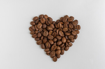 Coffee beans in the shape of heart on white background  top view