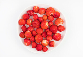 Ripe strawberries without tails on a plate on a white background. Berry background top view. The concept of natural products.