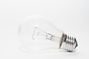 an outdated incandescent lamp with a base lies on a white background. isolate light bulb
