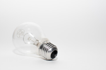 an outdated incandescent lamp with a base lies on a white background. isolate light bulb