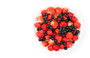 Berry collection of mountain ash and strawberries in a plate on a light background with a place to copy. Berry background. The concept of natural products.
