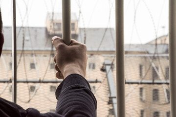 prisoner at the window of a prison cell