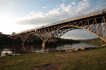 Fototapeta na wymiar View of steel arch bridge Strawberry Mansion Bridge crossing the Schuylkill River in Fairmount Park under sunset in Philadelphia, Pennsylvania, USA
