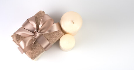 Spa set with candles and towels tied with a ribbon on a light background. The view from the top. Concept of Spa treatments.