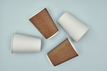 Paper cup in hand on a colored background. Eco-friendly materials in a coffee shop, biodegradable disposable tableware. Close up.
