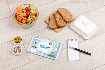 Organic food and tablet pc showing RESTART inscription, healthy nutrition composition