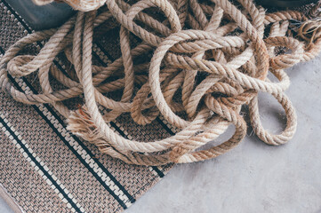 Pile of rope on concrete floor, background​ and​ texture..Brown rope pile or Long white rope.Knot of rope for floats for fishing nets.Fisherman's Rope