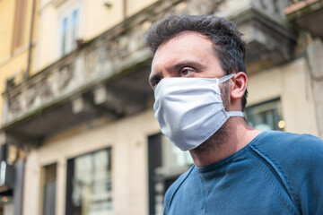 Black man wearing a white mask in a city street, coronavirus covid prevention concept