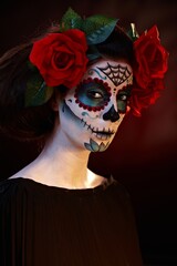 Woman wearing mexican santa muerte makeup, looking at camera.