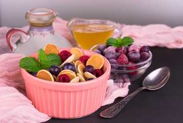 
Breakfast of small pancakes with berries and honey.