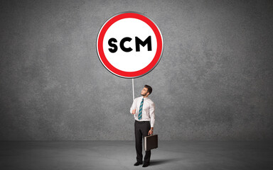 Young business person holdig traffic sign with SCM abbreviation, technology solution concept