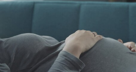 Tired pregnant woman sleeping on the sofa