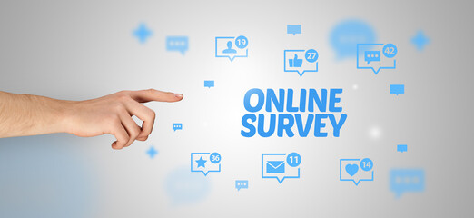 Close-Up of cropped hand pointing at ONLINE SURVEY inscription, social networking concept