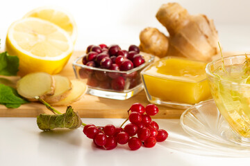 Natural products to boost immunity during a flu epidemic, coronavirus pandemic. Lemon, ginger, cranberry, viburnum, tea with lime flowers.