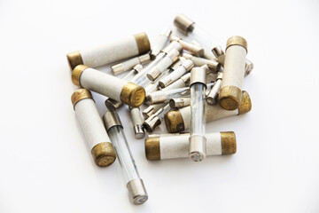 Old electric high-voltage fuses on a white background.