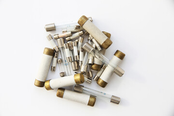 Old electric high-voltage fuses on a white background.