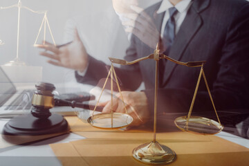 Business and lawyers discussing contract papers with brass scale on desk in office. Law, legal services, advice, justice and law concept picture with film grain effect