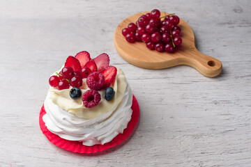 Pavlova meringue cake with cream and raspberries, blueberries, strawberries, currants
