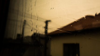 Water on the window. Rain on the window glass. Shadow on tree and nature through glass and rain. Shadow of house building