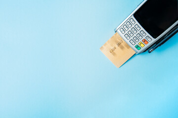 Close up of man hand holding bank card near payment terminal, Paypass technology concept