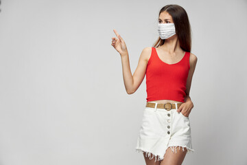 Woman in protective mask against coronavirus posing in studio.