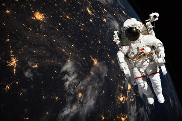 Astronaut walking in space with earth at night background. Elements of this image furnished by NASA