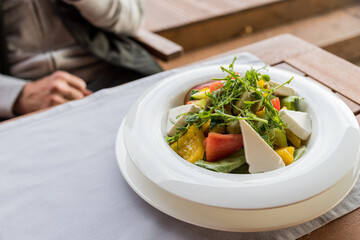 Greek salad with fresh vegetables, feta cheese and black olives.Mediterranean style salad with cheese, different tomatoes, yellow pepper,cucumber and lettuce. Healthy snack. tasty and healthy meal.