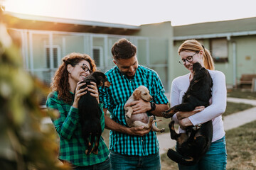 Young nice looking couple wants to adopt beautiful dog at animal shelter.