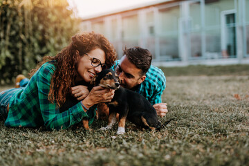 Young nice looking couple wants to adopt beautiful dog at animal shelter.