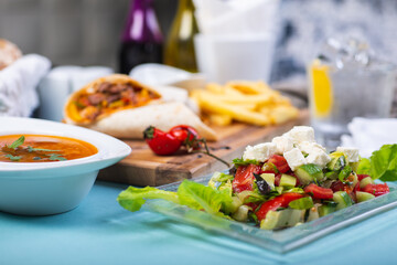 Top view of a restaurant table served with a multi-course set lunch and drink. Complex lunch.