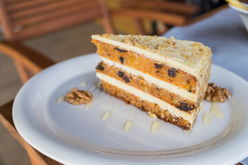 Close-up of walnut carrot cake on white plate.Raw vegan and gluten-free Carrot cake with nuts. Healthy Homemade dessert. Selective focus