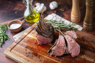 roasted lamb rack on wooden cutting board