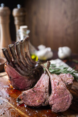 roasted lamb rack on wooden cutting board © ahirao