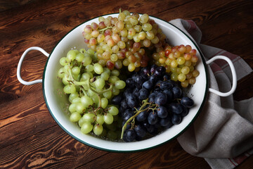Ripe multi-colored grapes in a white colander