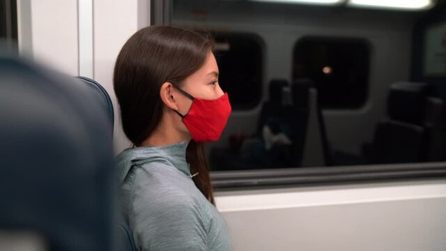 Face mask concept. Woman wearing mandatory mask in public transportation. Train transport commuter. Multiracial woman passenger using face mask on commute