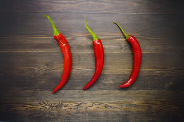 Red chilies on wooden background for logo or food symbol. 