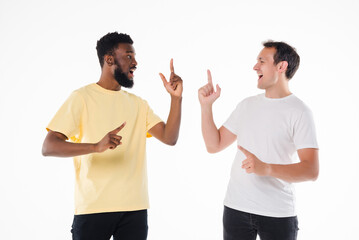 Two mixed race handsome men posing together pointed up isolated over white background