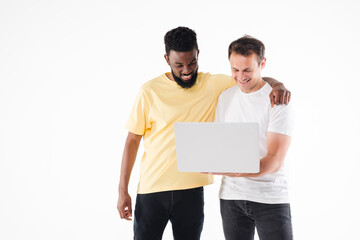 Portrait of two young man discussing over a laptop isolated over white background