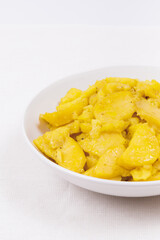 Stewed potato with spices in bowl.